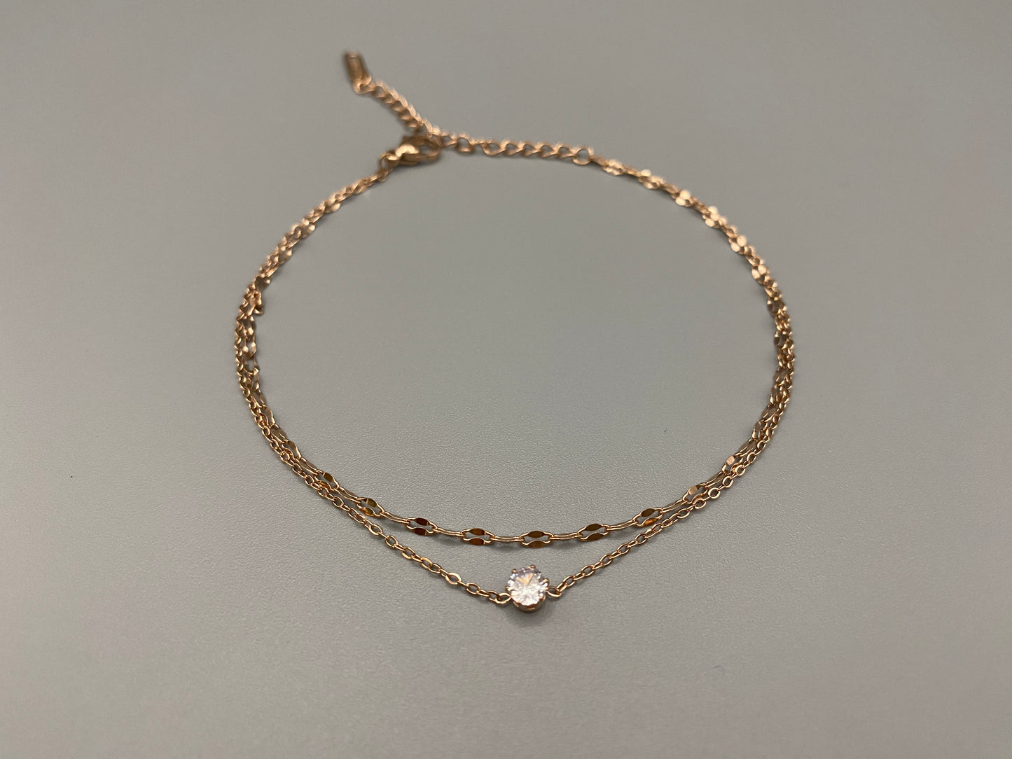 Aurora Twin Chain Bracelet in rose gold with a sophisticated twin chain design, adorned with zirconia gemstones. Waterproof and measures 18 cm with a 3 cm extender for adjustable fit.”