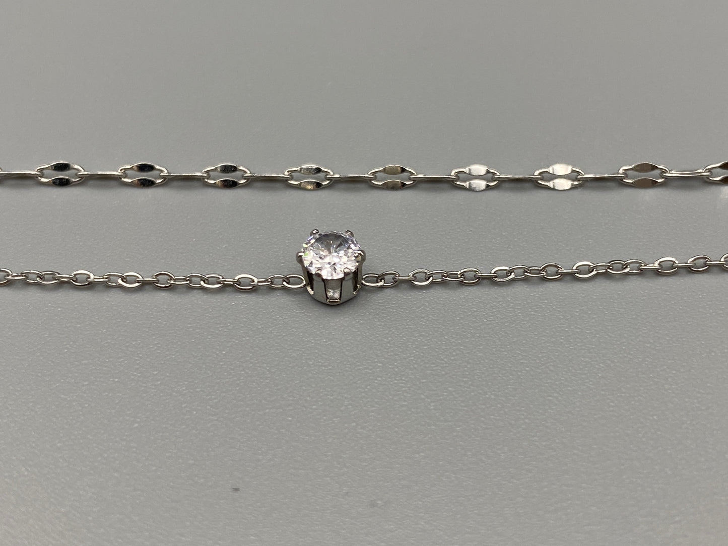 Aurora Twin Chain Bracelet in silver with a sophisticated twin chain design, adorned with sparkling zirconia gemstones. Waterproof and measures 18 cm with a 3 cm extender for adjustable fit.”