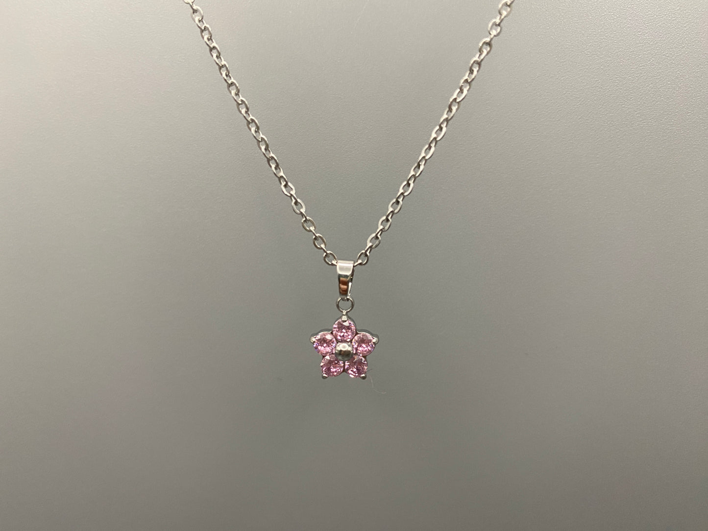 “Blossom Silver Pendant Necklace with a plum blossom design, featuring colourful cubic zirconia stones in a claw setting. Made from durable stainless steel with PVD plating. Measures 46 cm with a 5 cm adjustment.”