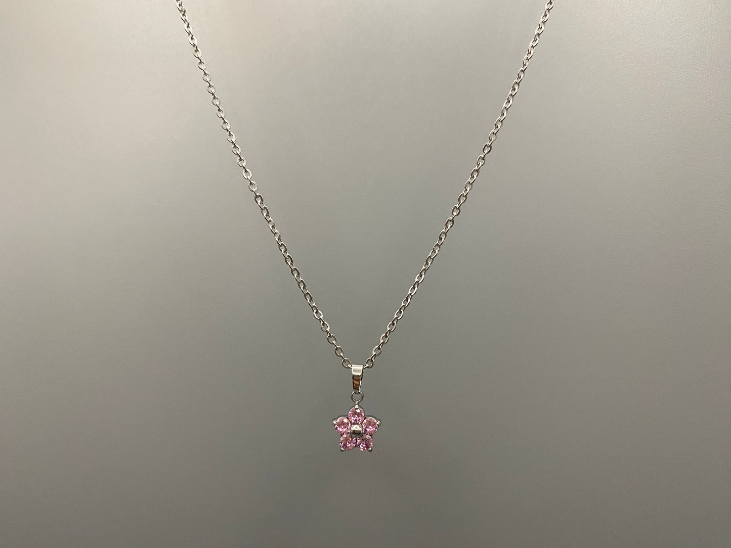 “Blossom Silver Pendant Necklace with a plum blossom design, featuring colourful cubic zirconia stones in a claw setting. Made from durable stainless steel with PVD plating. Measures 46 cm with a 5 cm adjustment.”