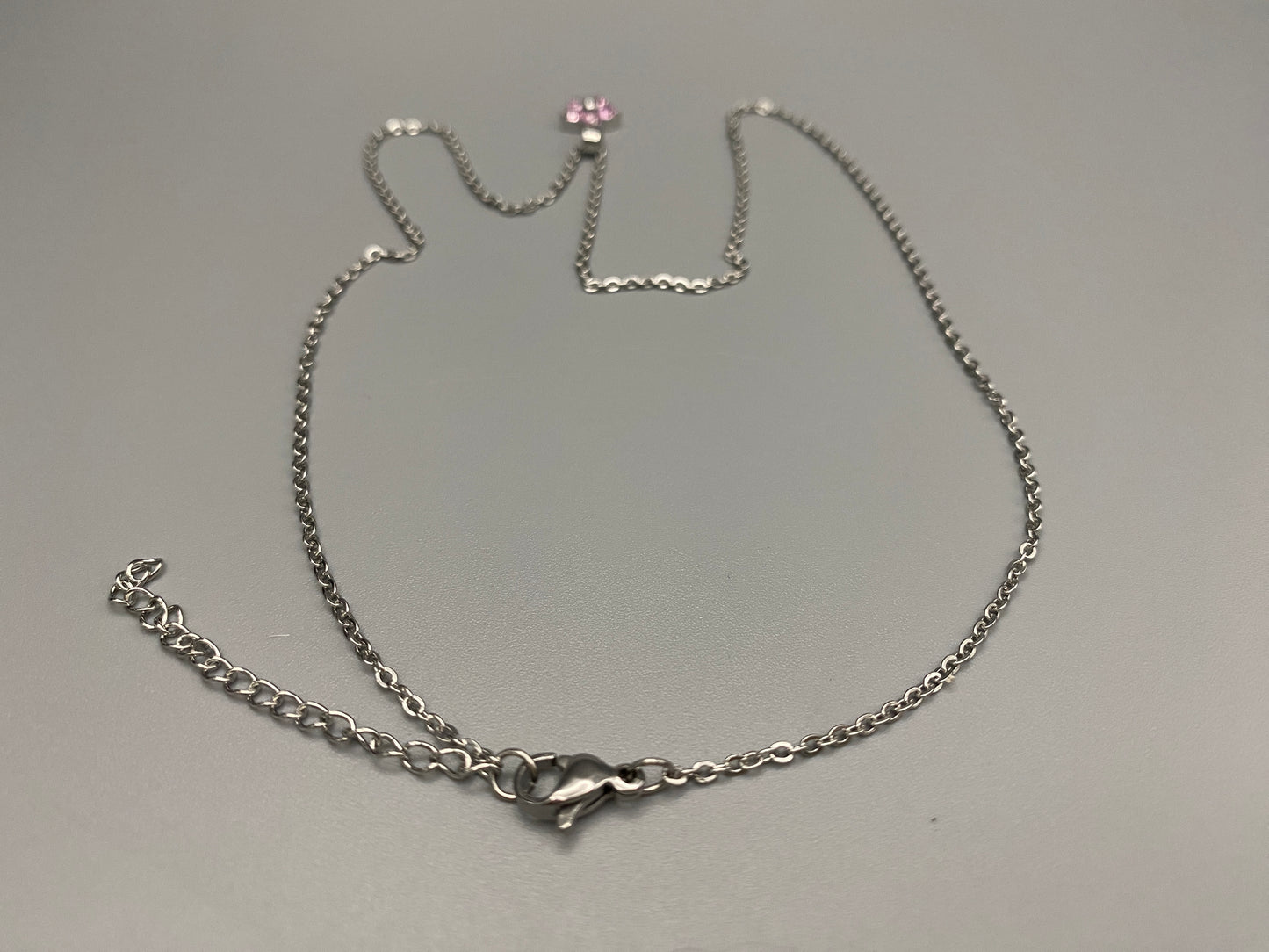 “Blossom Silver Pendant Necklace with a plum blossom design, featuring colourful cubic zirconia stones in a claw setting. Made from durable stainless steel with PVD plating. Measures 46 cm with a 5 cm adjustment.”