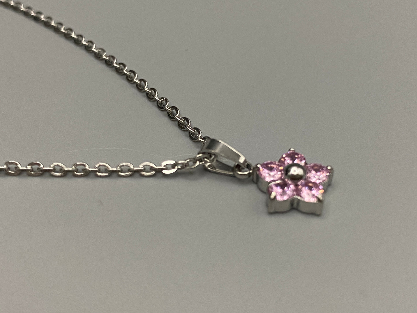 “Blossom Silver Pendant Necklace with a plum blossom design, featuring colourful cubic zirconia stones in a claw setting. Made from durable stainless steel with PVD plating. Measures 46 cm with a 5 cm adjustment.”