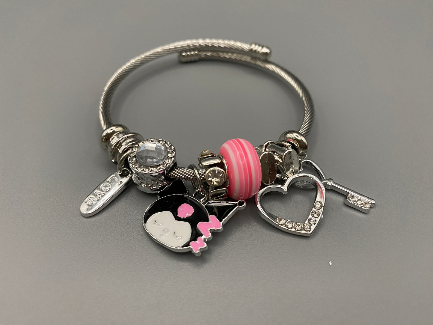 “Cartoon Character Bracelet in pink with a playful and stylish design, made from durable stainless steel, alloy charms, crystals, and glass beads. Adjustable 6cm diameter for a comfortable fit.”