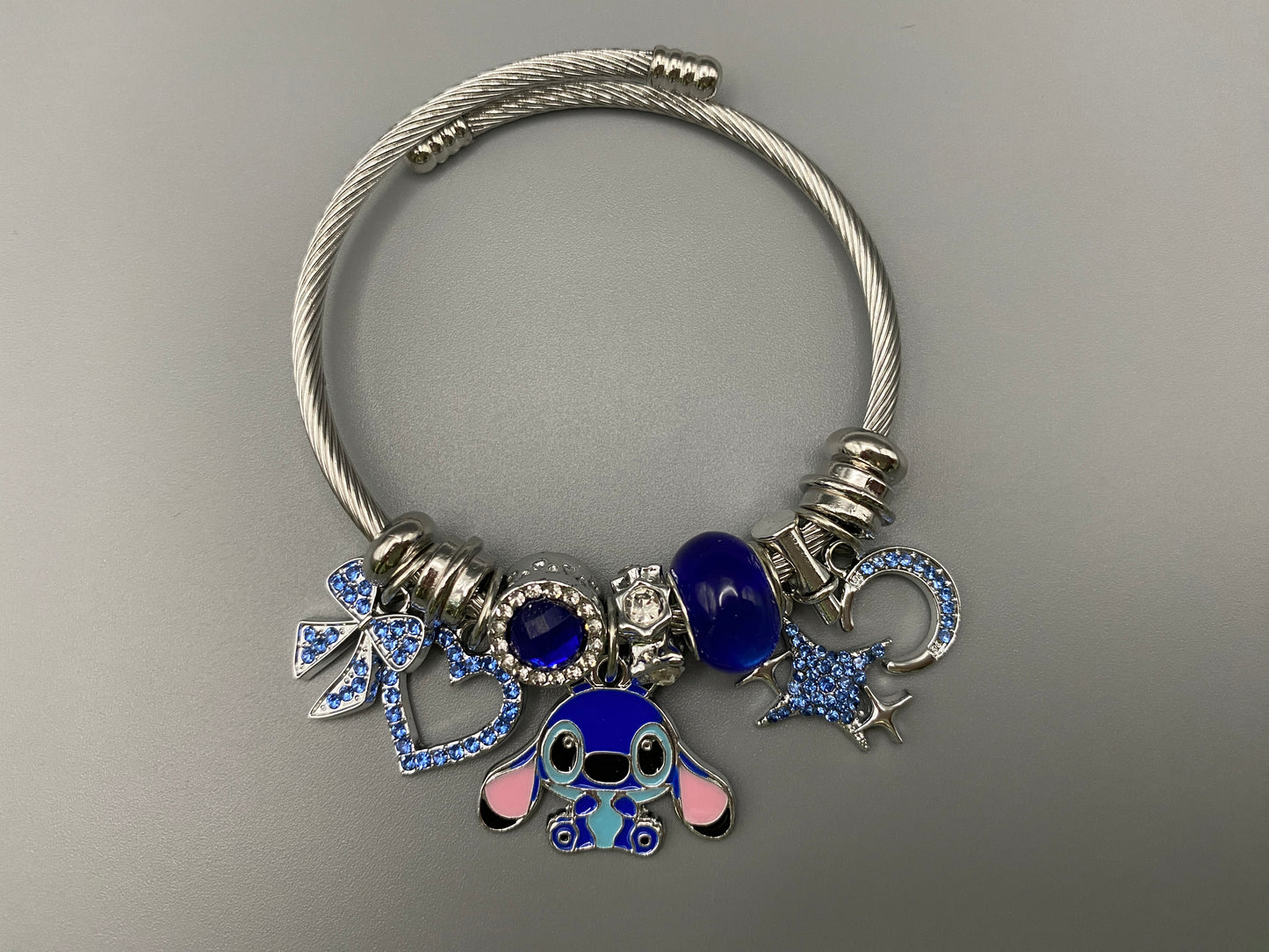 “Cartoon Character Bracelet in Blue with a playful and stylish design, made from durable stainless steel, alloy charms, crystals, and glass beads. Adjustable 6cm diameter for a comfortable fit.”