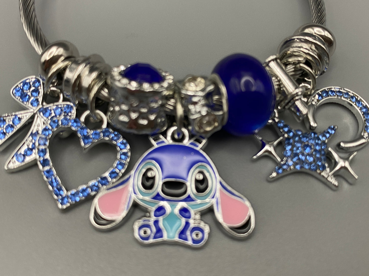 “Cartoon Character Bracelet in Blue with a playful and stylish design, made from durable stainless steel, alloy charms, crystals, and glass beads. Adjustable 6cm diameter for a comfortable fit.”