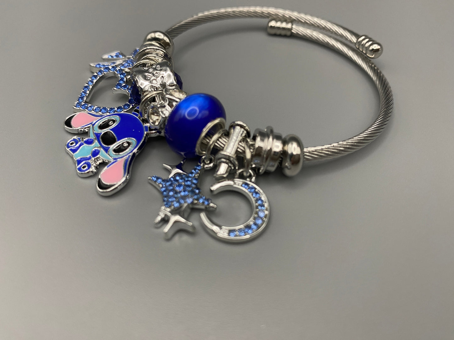 “Cartoon Character Bracelet in Blue with a playful and stylish design, made from durable stainless steel, alloy charms, crystals, and glass beads. Adjustable 6cm diameter for a comfortable fit.”