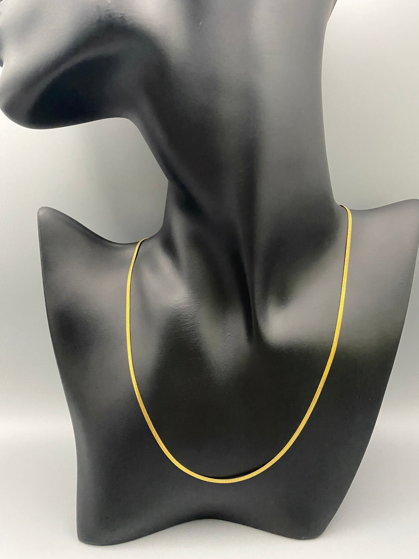 Dahlia Flat Snake Chain Gold Necklace. Sleek and modern design with a flat snake chain, perfect for adding elegance to any outfit. Key Features: Elegant Design: Flat snake chain with gold plating for a sophisticated look. Stainless Steel: Durable and tarnish-resistant. 18k Gold-Plated: Luxurious finish. Anti Tarnish & Waterproof: Maintains shine and luster over time. Size: 40 cm with a 5 cm extender for adjustable fit. Width: 2 mm for a delicate yet noticeable presence.