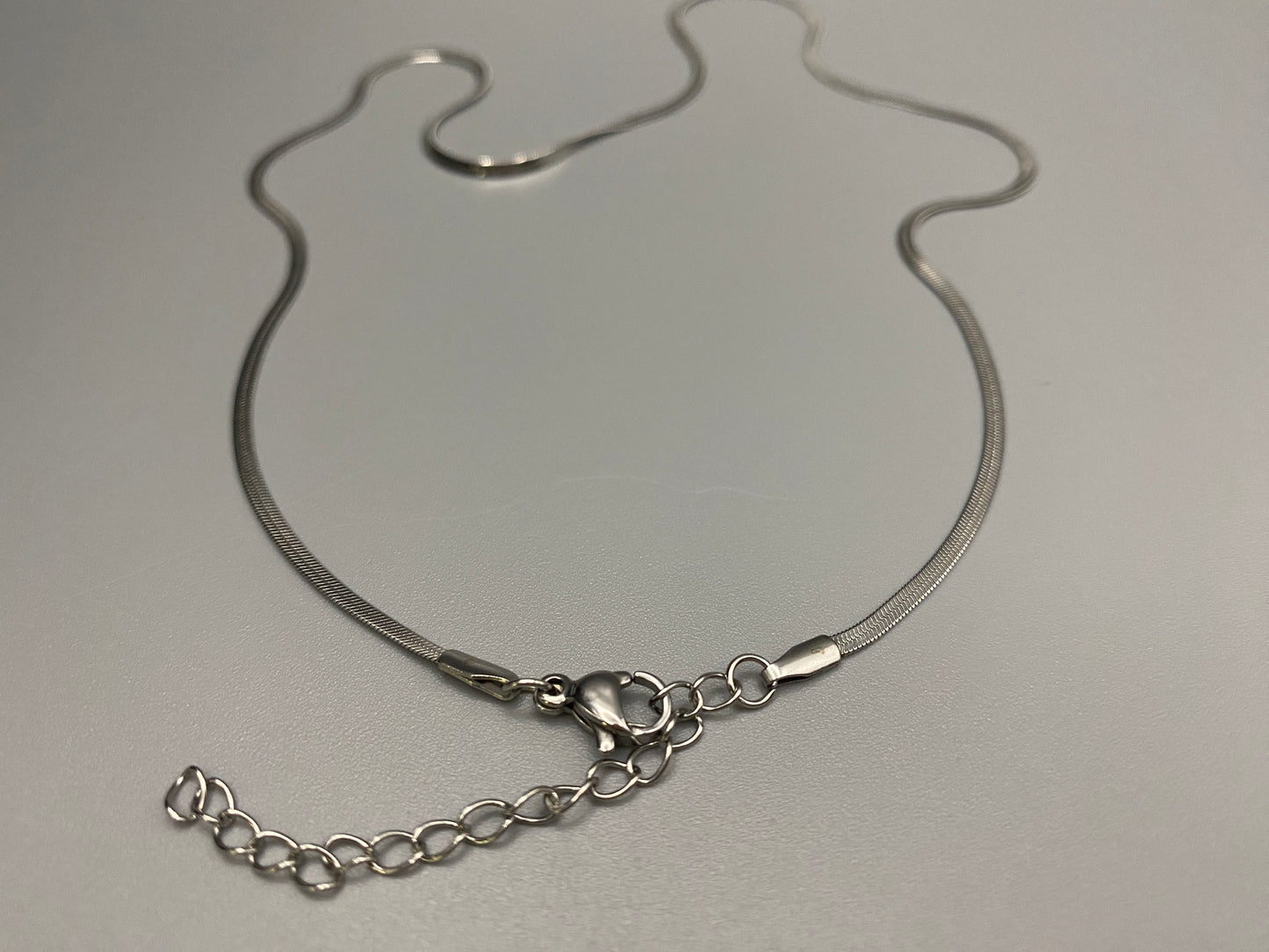Dahlia Flat Snake Chain Silver Necklace. Sleek and sophisticated accessory. High-quality stainless steel, anti-tarnish, waterproof. Flat snake chain, 2mm width. Adjustable length: 40cm + 5cm extender. Modern and trendy design, perfect for layering or solo wear.