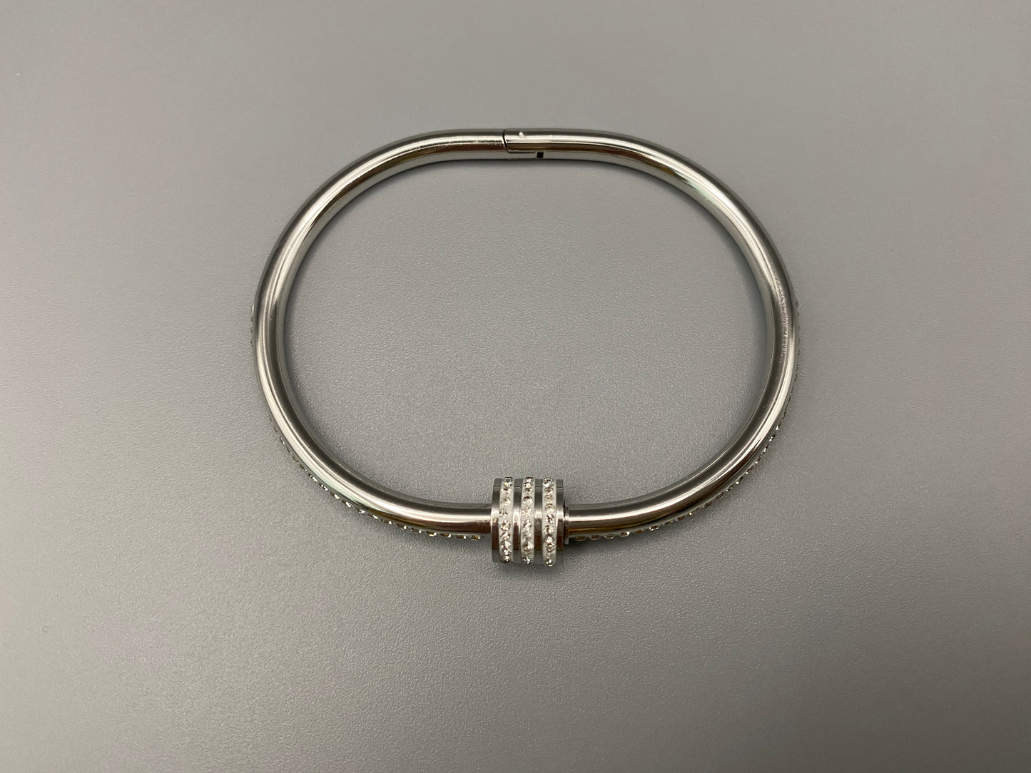 “Eclipse Encrusted Bangle Bracelet in silver with an encrusted gem inlay, featuring silver plating and a thread open and close mechanism for easy adjustment. Made from high-quality materials for long-lasting wear.”