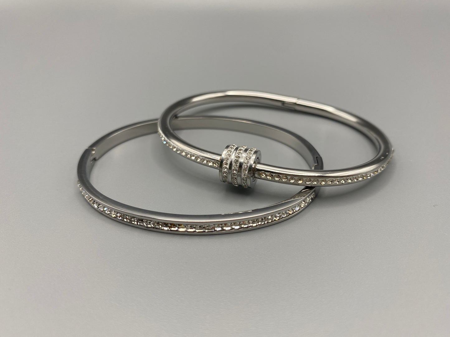 “Eclipse Encrusted Bangle Bracelet in silver with an encrusted gem inlay, featuring silver plating and a thread open and close mechanism for easy adjustment. Made from high-quality materials for long-lasting wear.”
