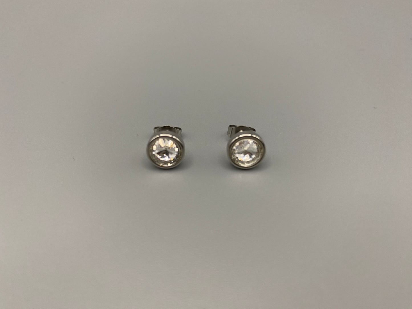 Elara Stud Earrings Silver Chic stud earrings featuring dazzling AAA Zircon stones set in high-quality 304 stainless steel, silver plated, with an 8mm size and micro insert inlay technology. These earrings offer a perfect blend of elegance and durability.