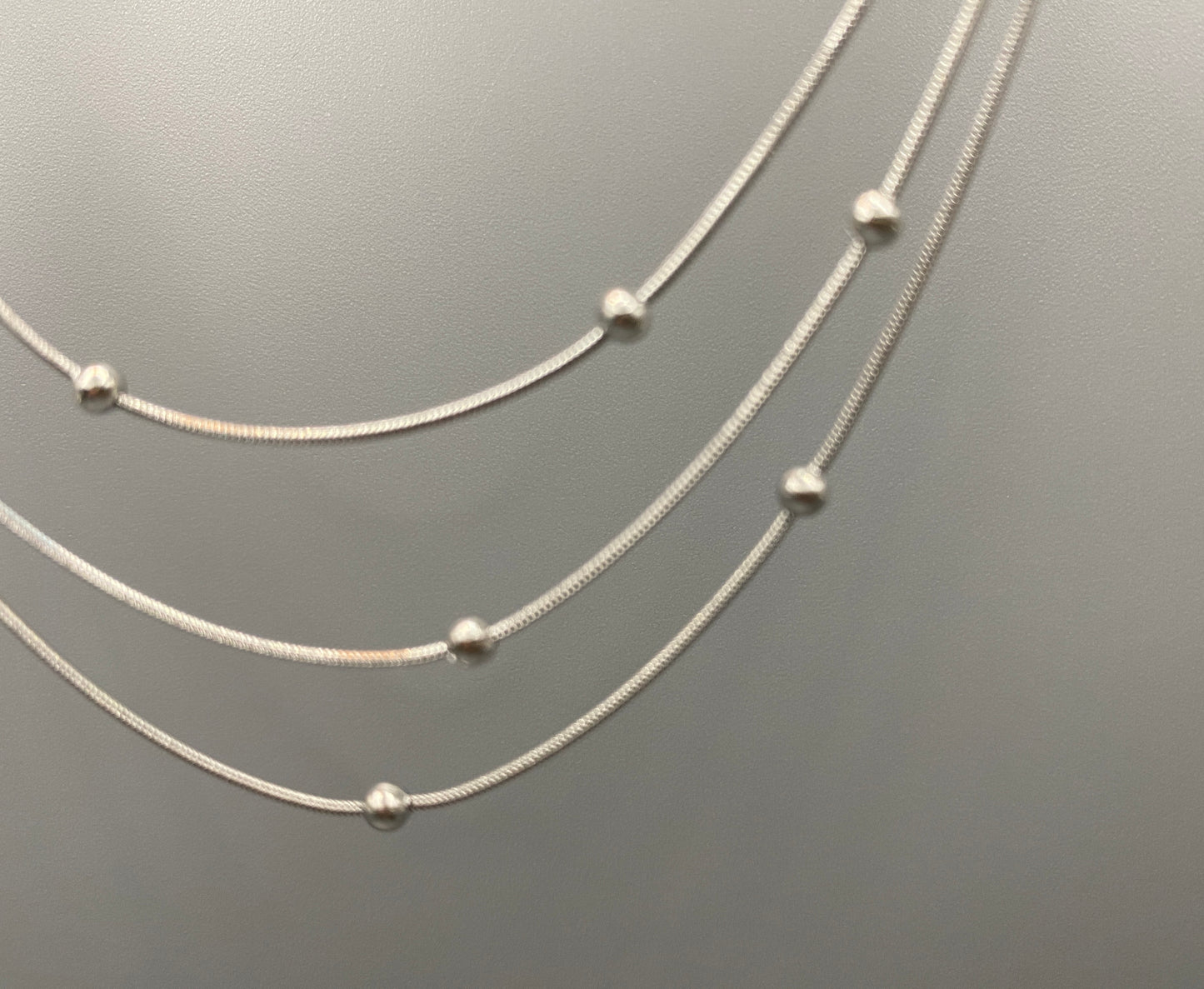 Elegant tri-chain design with bead accents. silver plated, PVD plated for durability. Adjustable length: 40 cm + 5 cm extender. Versatile for layering or solo wear.