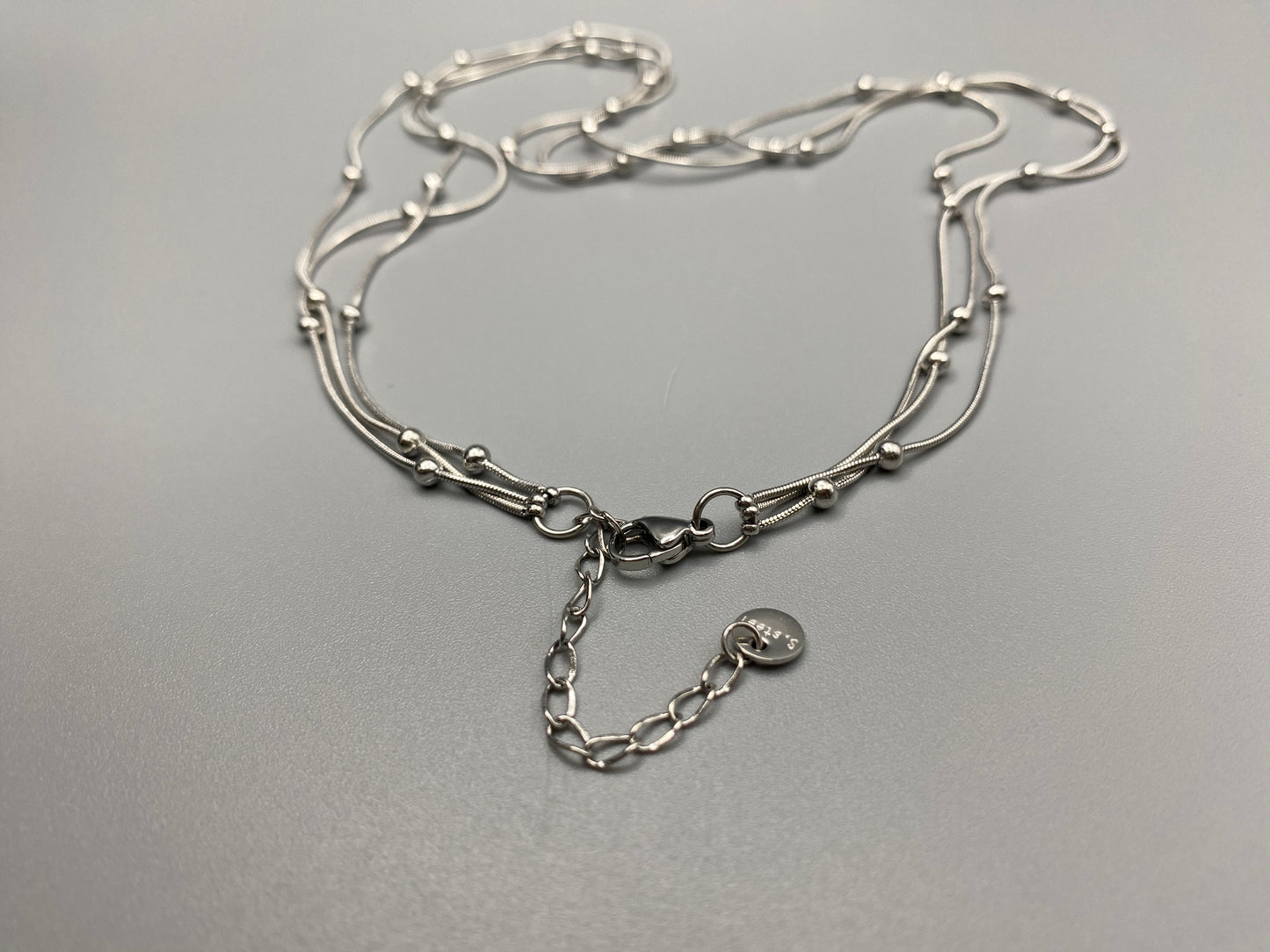 Elegant tri-chain design with bead accents. silver plated, PVD plated for durability. Adjustable length: 40 cm + 5 cm extender. Versatile for layering or solo wear.