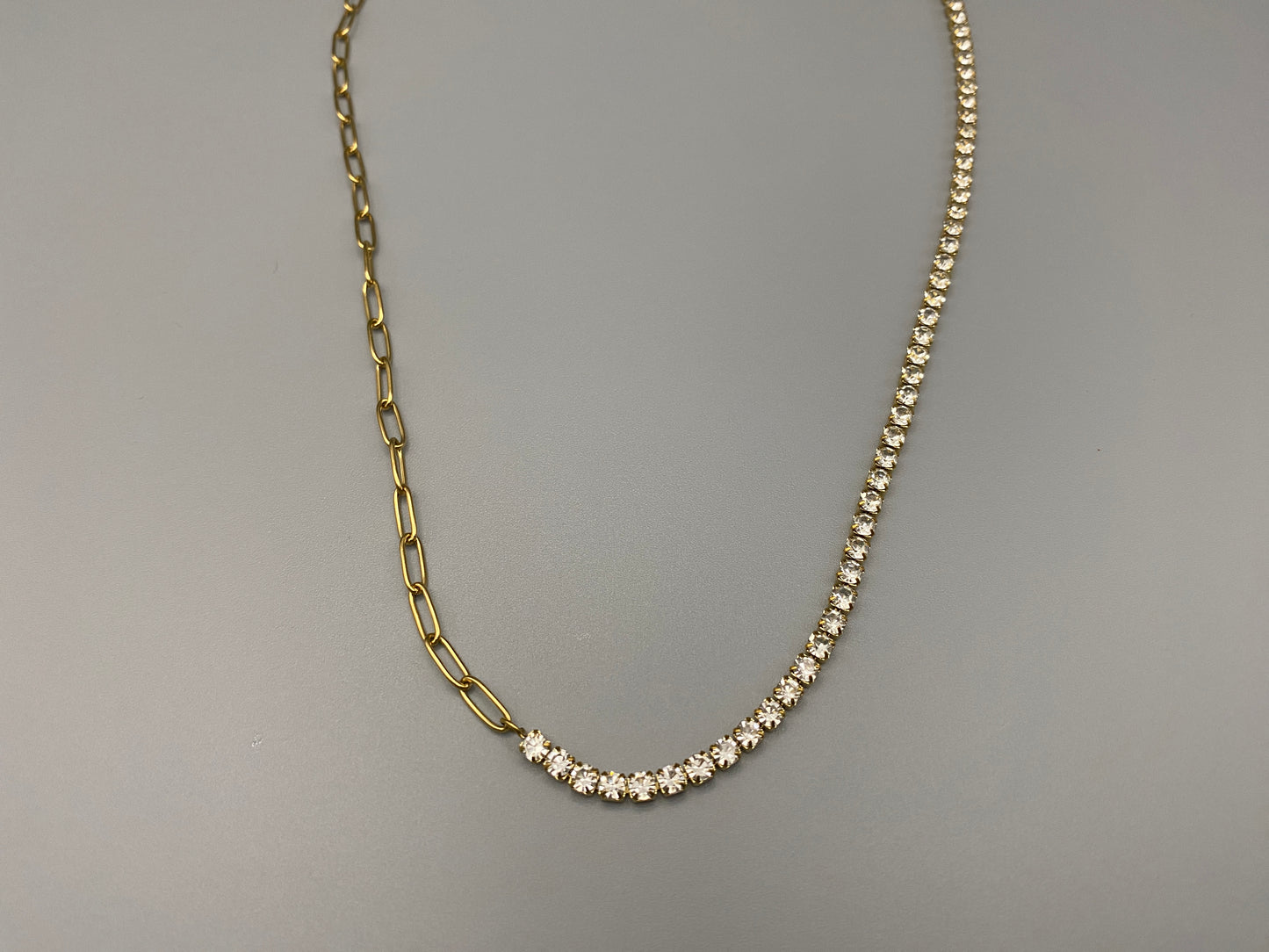 “Gemma Necklace in gold with iced-out zircon paperclip chain, crafted from tarnish-free stainless steel and plated with 18K gold. Measures 45 cm in length with a 5 cm adjustment. Waterproof and perfect for daily wear or special occasions.”