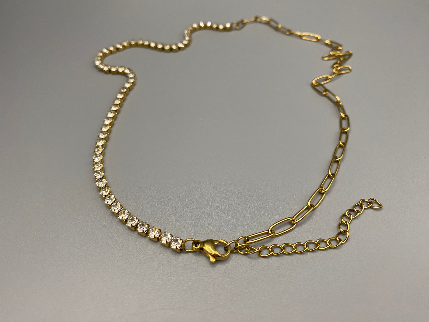 Gemma Necklace in gold with iced-out zircon paperclip chain, crafted from tarnish-free stainless steel and plated with 18K gold. Measures 45 cm in length with a 5 cm adjustment. Waterproof and perfect for daily wear or special occasions.”