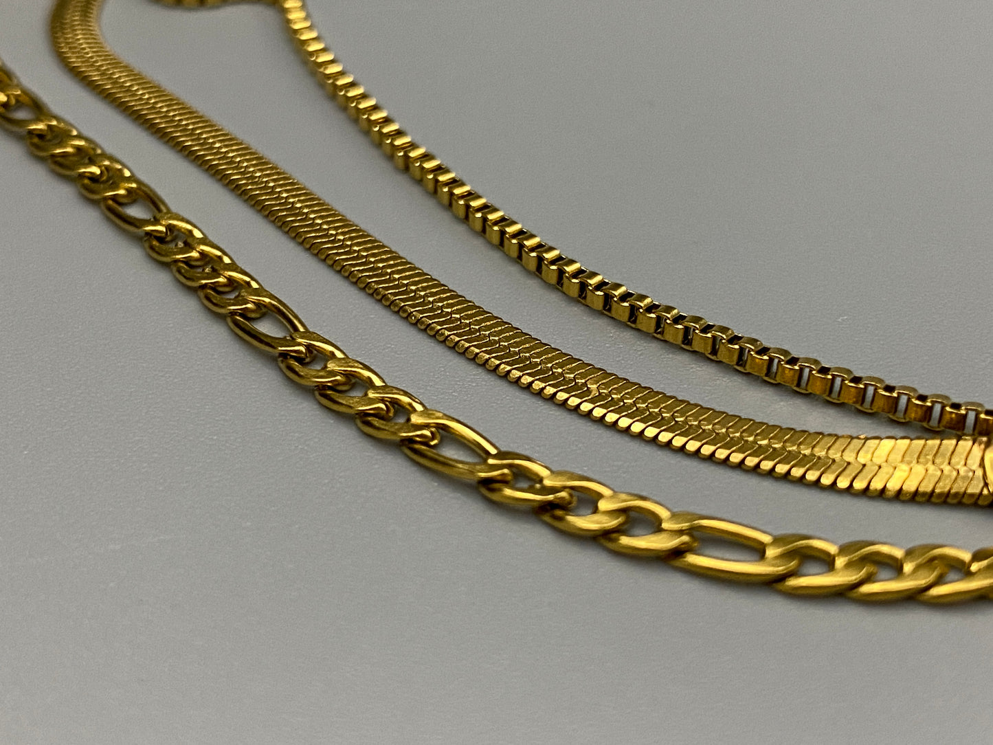 Gina Three Layered Gold Chain Necklace. Three delicate chains layered for a sophisticated look. 18k gold plated, PVD plated for durability. Stainless steel, corrosion-resistant. Adjustable length: 40 cm + 5 cm extender. Versatile for casual and formal wear.