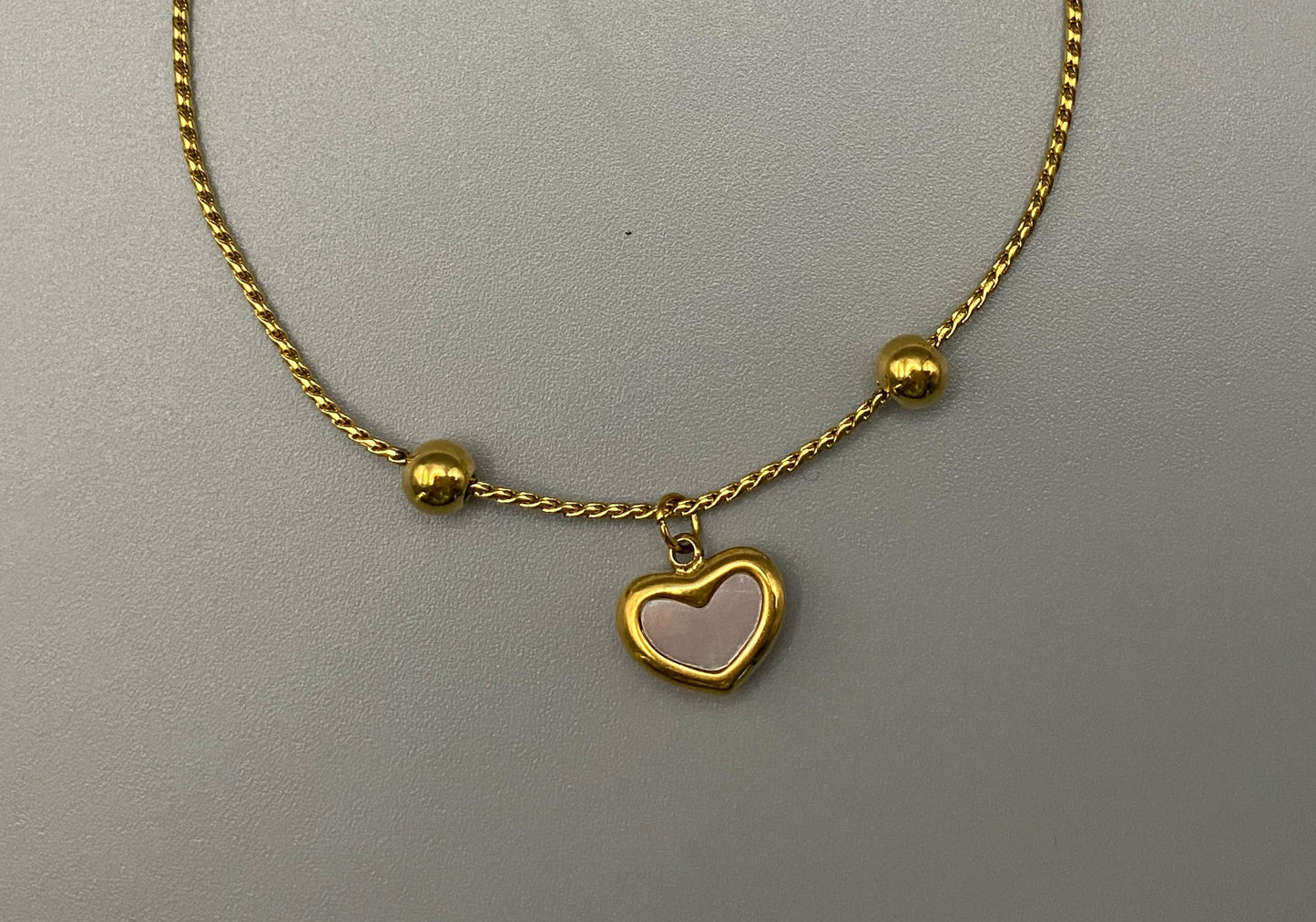 “Helena Heart Bracelet in gold with a white shell heart pendant, crafted from high-quality stainless steel and plated with 18K gold. Adjustable, waterproof, tarnish-free, and environmentally friendly.”