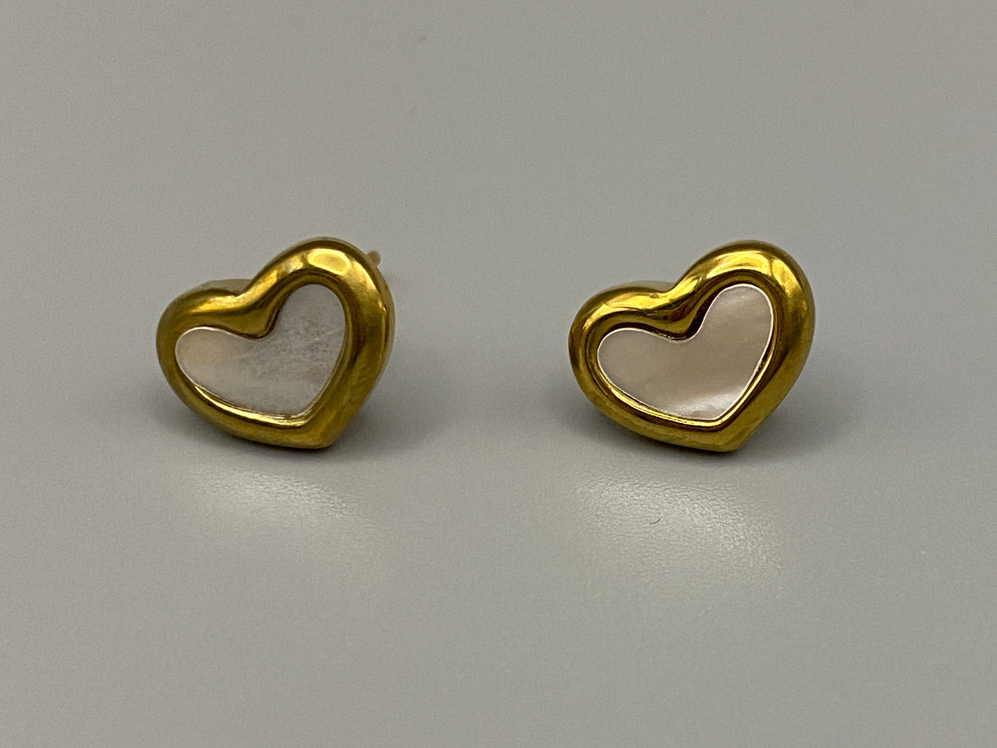 Versatile and elegant Helena Heart Earrings featuring a white shell heart pendant, crafted from high-quality titanium steel and plated with 18k gold. These earrings are waterproof, tarnish-free, and environmentally friendly, offering a trendy style and superior craftsmanship.
