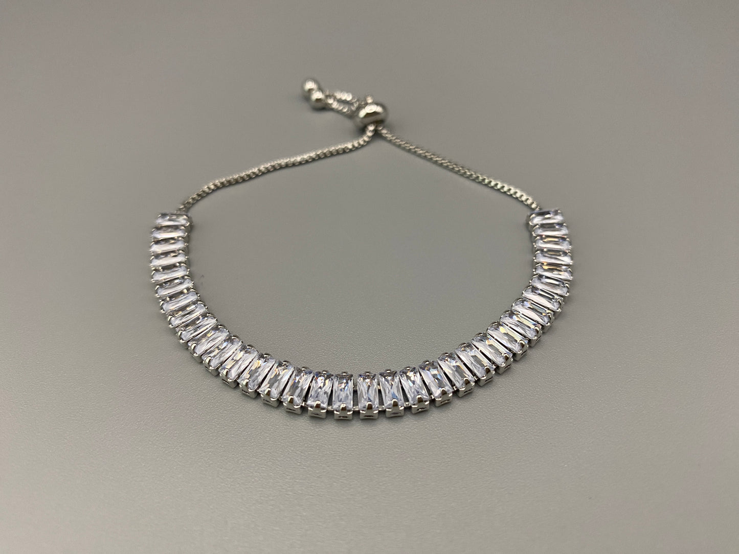 “Isdis Bracelet with a luxurious hip hop design, made from high-quality copper and adorned with sparkling zirconia stones. Features an adjustable closure with pull strings.”