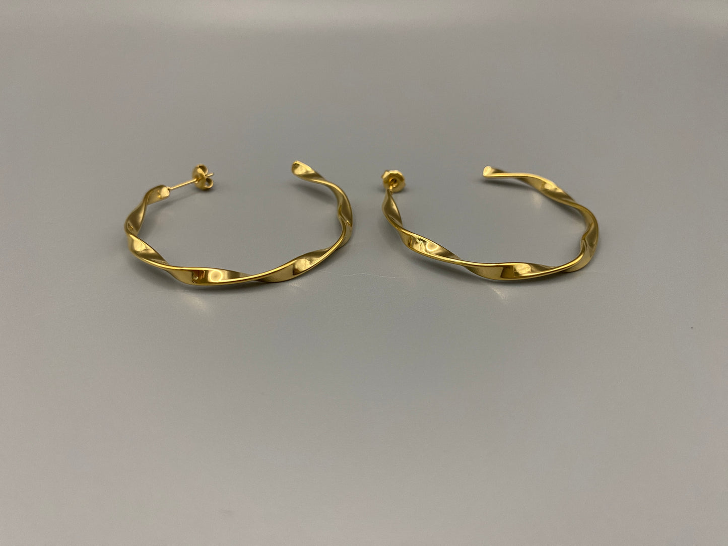“Leanne C Shape Earrings Gold: Fashion-forward twisted wire earrings with an irregular C-shaped design, crafted from high-quality stainless steel and plated with luxurious 18K gold. Perfect for any occasion.”