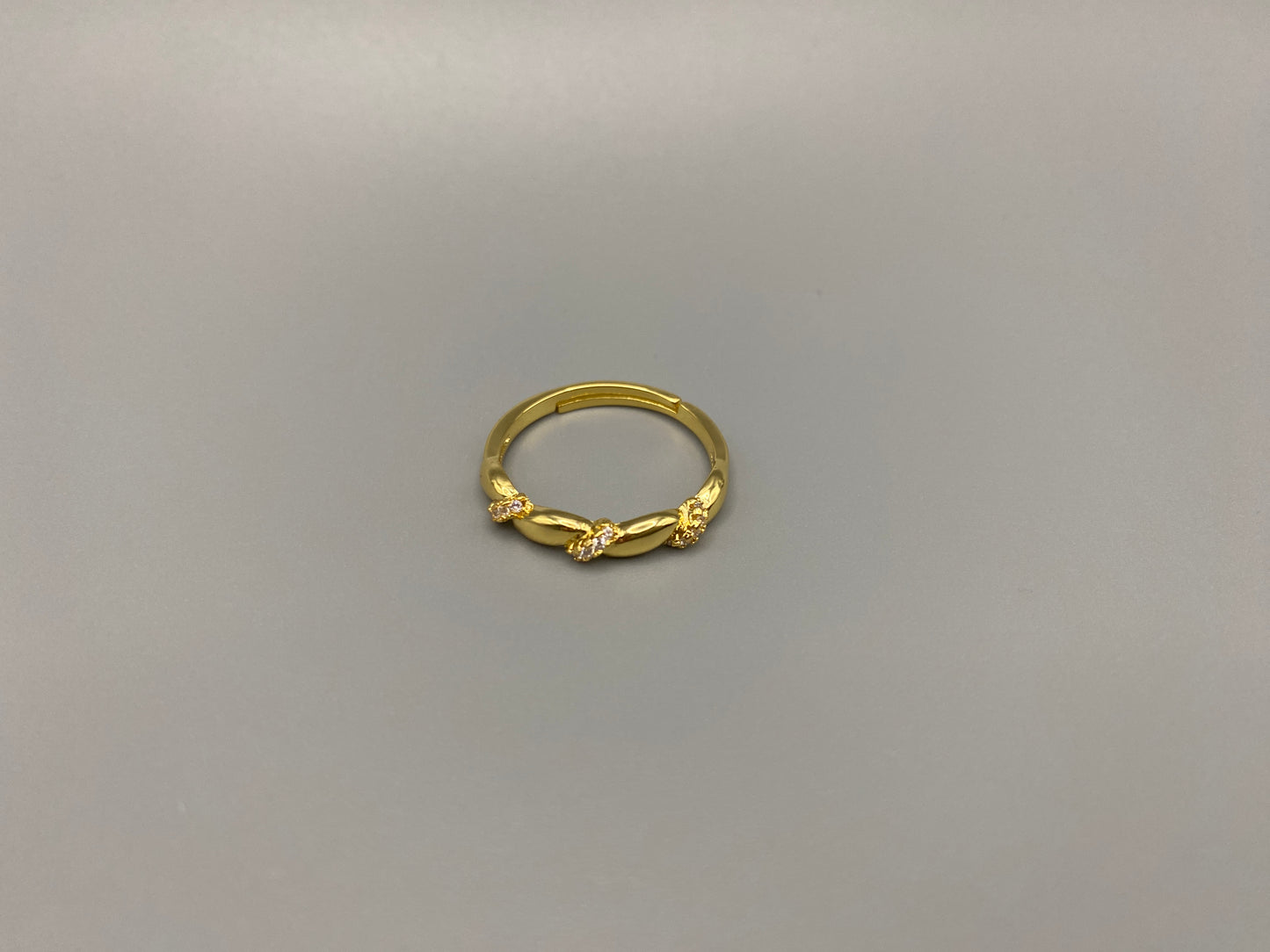 Olivia Adjustable Ring Gold: This exquisite piece is 18k gold plated, offering a luxurious shine and timeless appeal. The ring is waterproof and non-tarnish, ensuring it maintains its beauty over time. Cubic zirconia accents add sparkle and elegance, while the adjustable design ensures a perfect fit for any finger size. Make a statement with this stunning piece that complements any look.