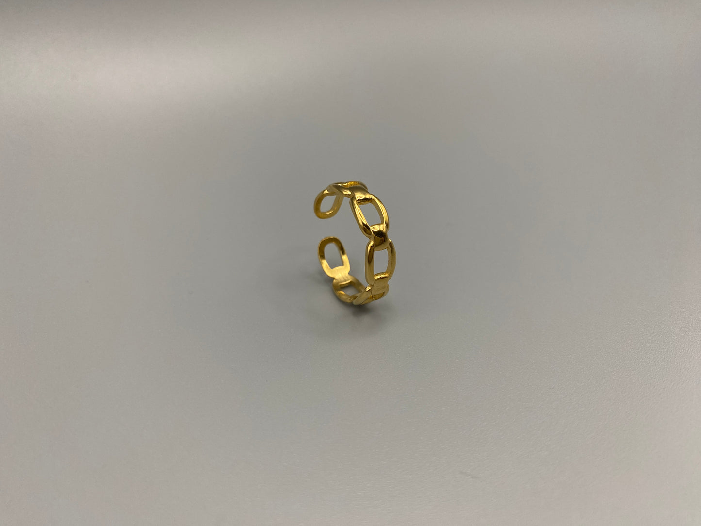 Phoebe Gold Ring: Discover the Phoebe Gold Ring, a fashionable and versatile piece perfect for any occasion. This 18K gold-plated stainless steel ring features a hollow geometric link chain design. It is resizable to size 6, making it a trendy and adaptable accessory. Ideal for daily wear or special events like anniversaries and parties, this ring is both nickel-free and lead-free, ensuring it is safe for all skin types.