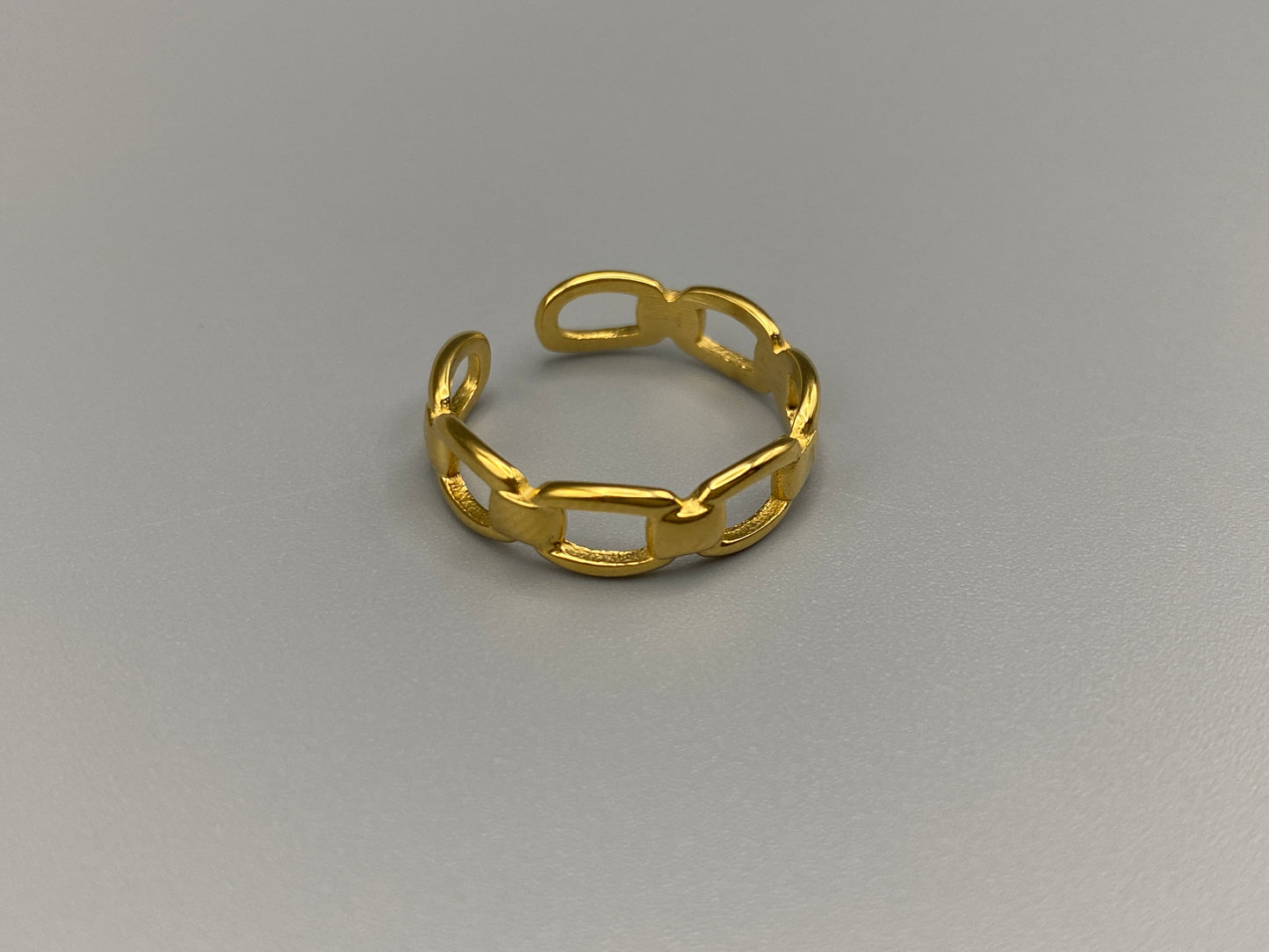 Phoebe Gold Ring: Discover the Phoebe Gold Ring, a fashionable and versatile piece perfect for any occasion. This 18K gold-plated stainless steel ring features a hollow geometric link chain design. It is resizable to size 6, making it a trendy and adaptable accessory. Ideal for daily wear or special events like anniversaries and parties, this ring is both nickel-free and lead-free, ensuring it is safe for all skin types.