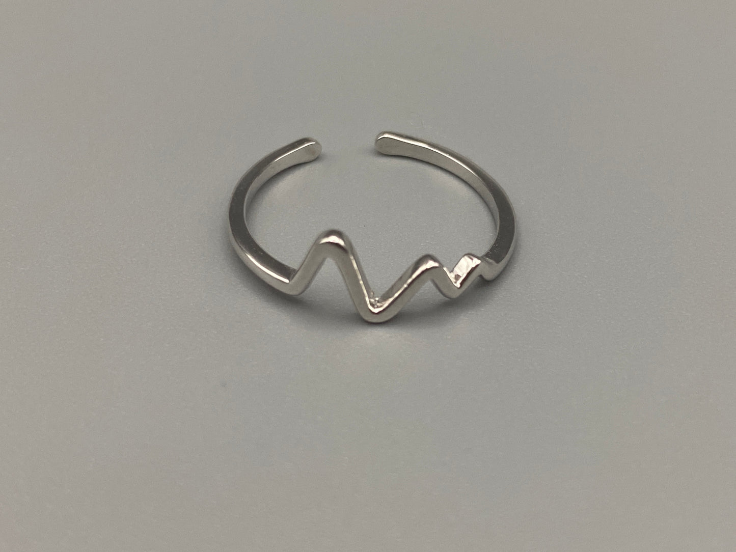 Pulse Ring Silver: This adjustable ring features a heartbeat pattern, crafted from high-quality 925 sterling silver and plated with a non-tarnish, waterproof finish. It is designed to be anti-allergy, making it perfect for any occasion, whether it’s an anniversary, engagement, wedding, or party.