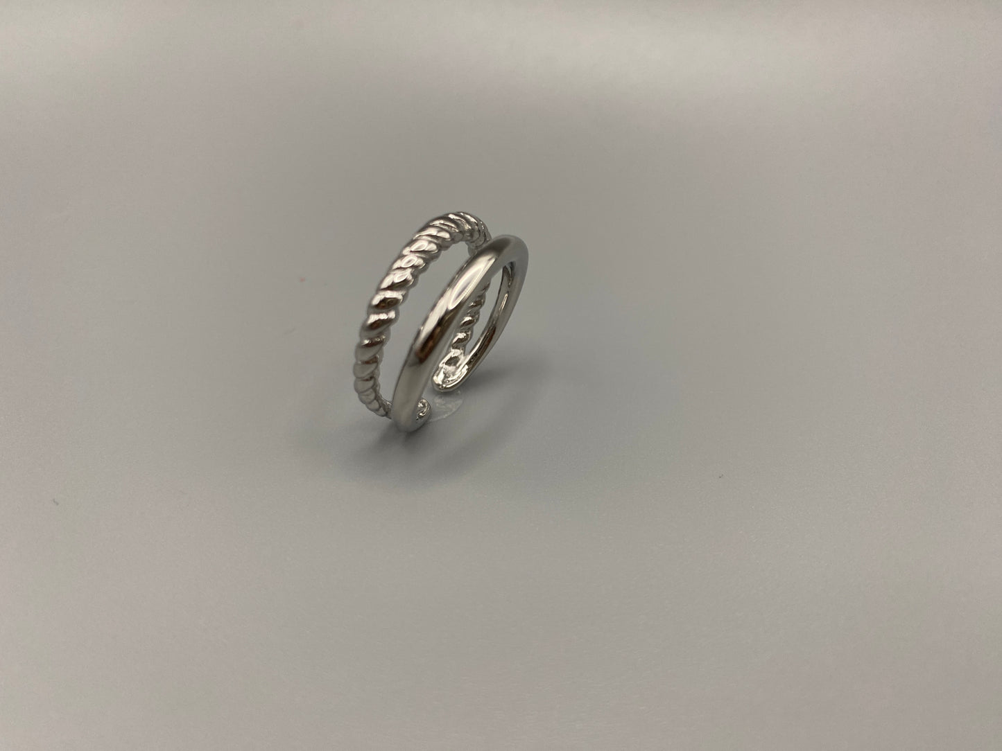 Selene Twin Band Ring Silver: This ring features a unique combination of a textured rope band and a smooth plain band, both gold plated for a luxurious finish. The titanium PVD ensures durability and resistance to wear, while the stainless steel construction adds strength and longevity. The unique twin band design combines elegance and modernity. Available in ring size 7, it is perfect for those who wear this size. Make a statement with this versatile and chic accessory that complements any look.