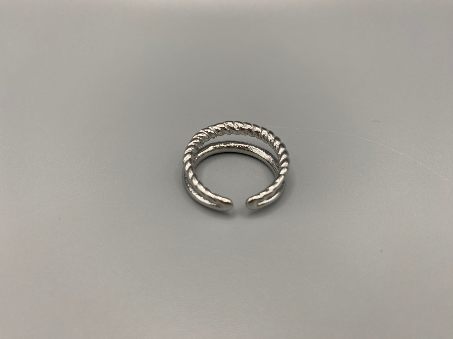 Selene Twin Band Ring Silver: This ring features a unique combination of a textured rope band and a smooth plain band, both gold plated for a luxurious finish. The titanium PVD ensures durability and resistance to wear, while the stainless steel construction adds strength and longevity. The unique twin band design combines elegance and modernity. Available in ring size 7, it is perfect for those who wear this size. Make a statement with this versatile and chic accessory that complements any look.