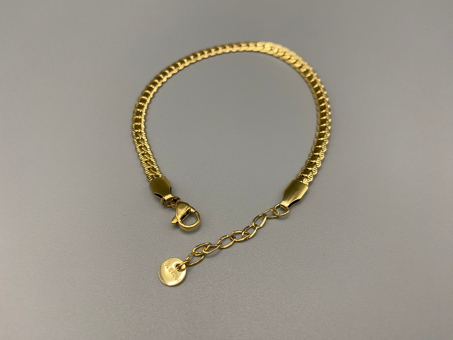 “Seraphina Bracelet in gold with a unique snake-linked design, featuring luxurious gold plating. Adjustable length of 17 cm with a 3 cm extension. Durable construction ensures long-lasting wear and tarnish resistance.”