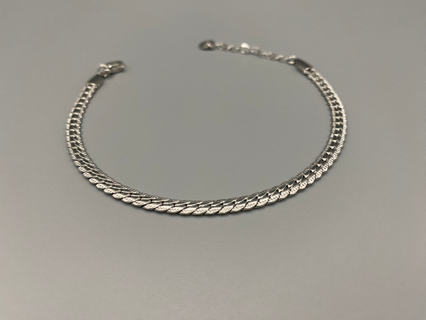 “Seraphina Bracelet in Silver with a unique snake-linked design, featuring luxurious Silver plating. Adjustable length of 17 cm with a 3 cm extension. Durable construction ensures long-lasting wear and tarnish resistance.”