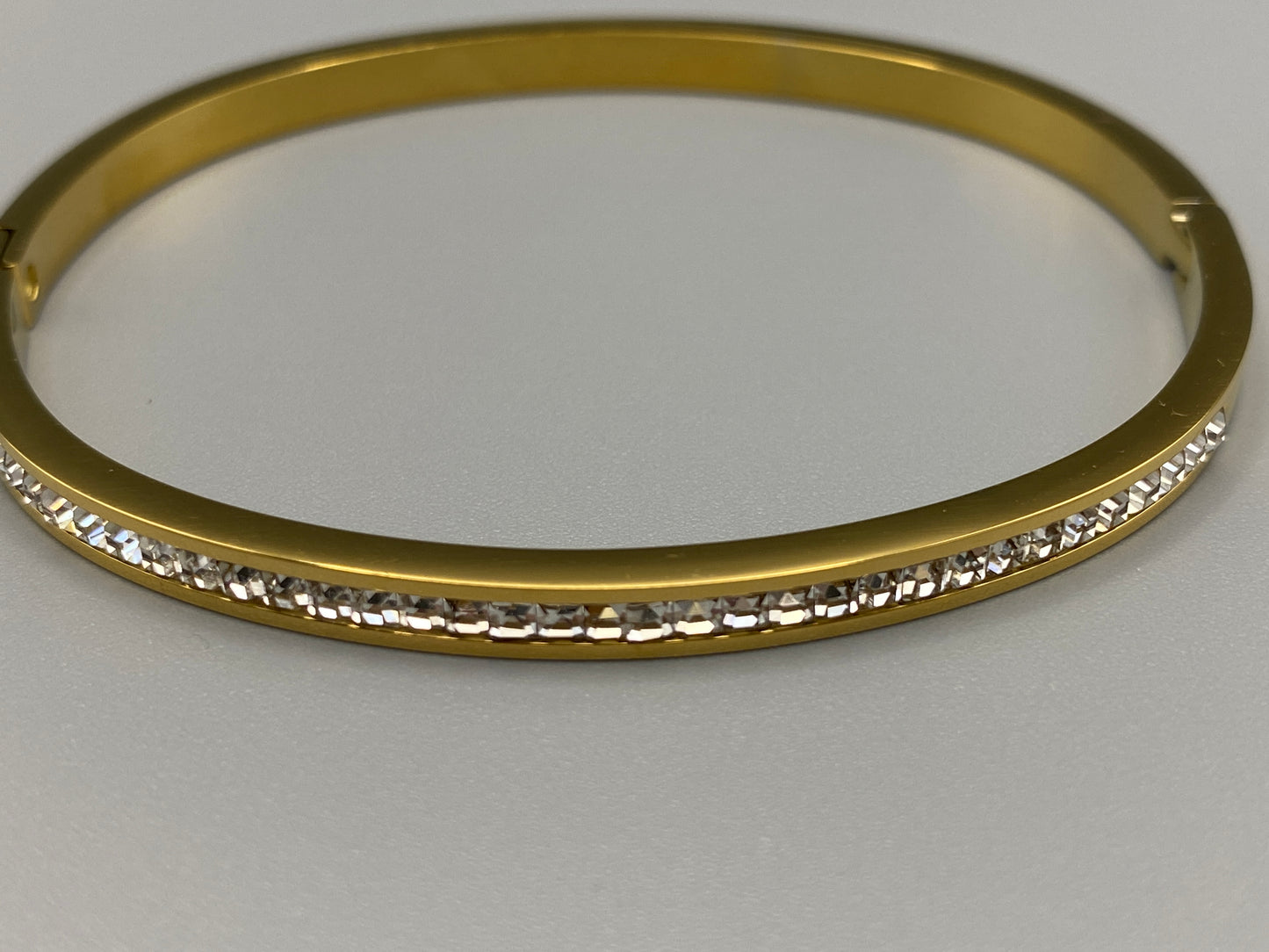 “Simone Encrusted Bangle in gold with 18K gold plating and gemstone inlay, offering a radiant and luxurious finish. Durable construction ensures long-lasting wear and tarnish resistance. Perfect for both everyday wear and special occasions.”