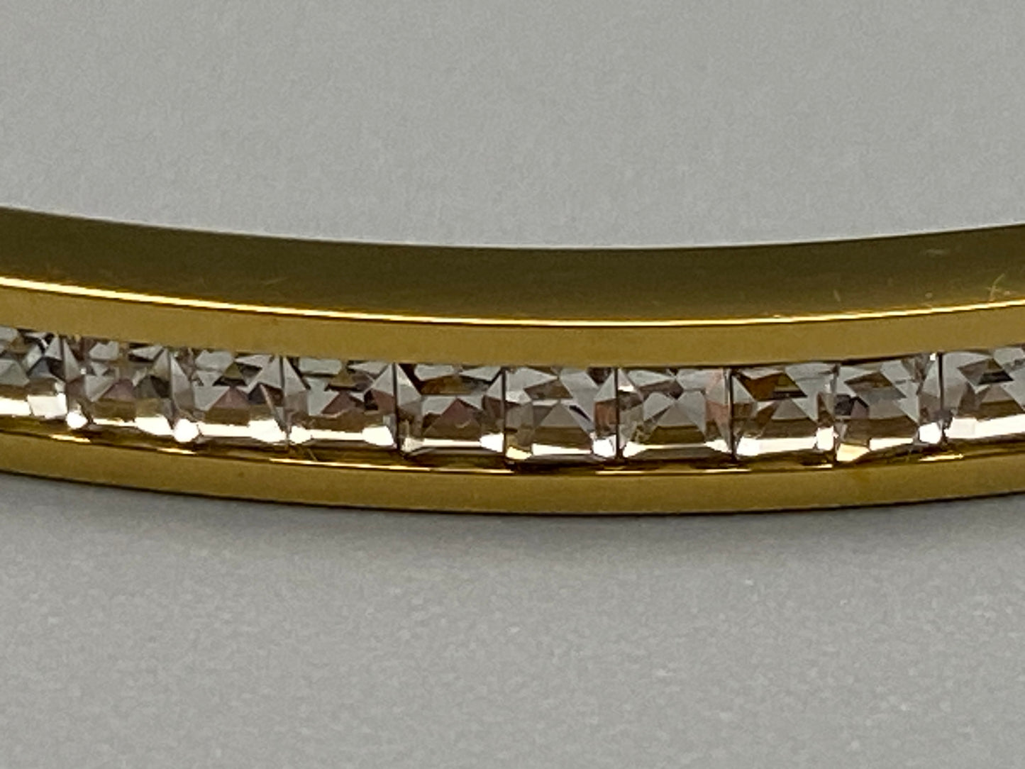“Simone Encrusted Bangle in gold with 18K gold plating and gemstone inlay, offering a radiant and luxurious finish. Durable construction ensures long-lasting wear and tarnish resistance. Perfect for both everyday wear and special occasions.”