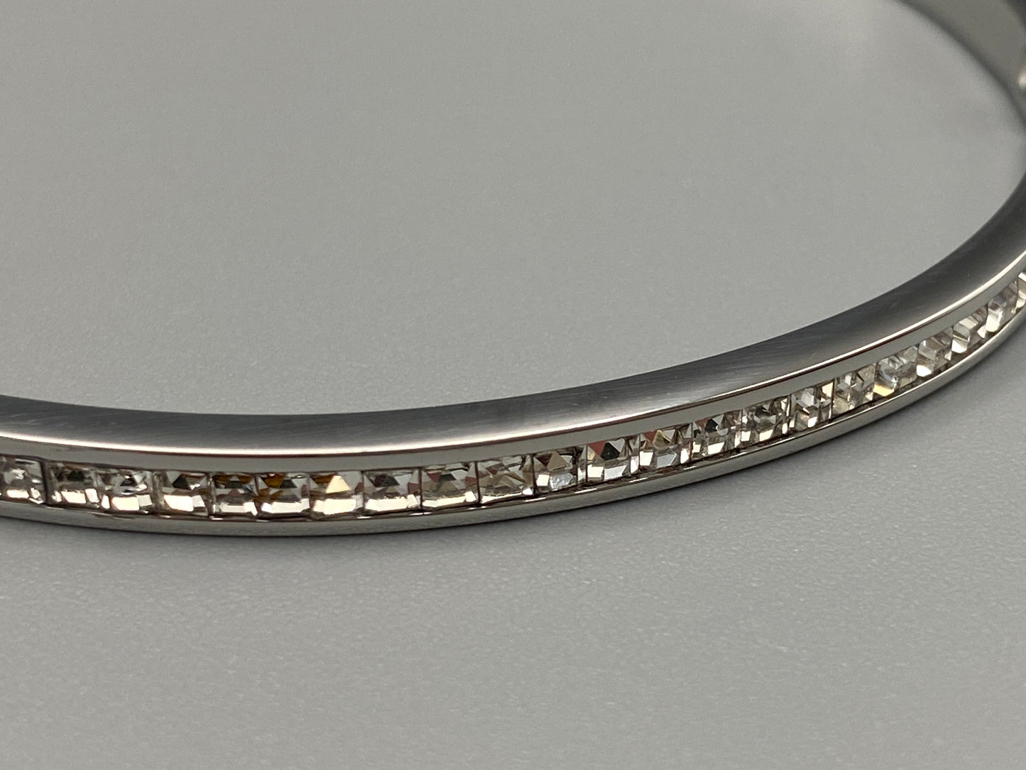 Simone Encrusted Bangle in silver with silver plating and gemstone inlay, offering a radiant and luxurious finish. Durable construction ensures long-lasting wear and tarnish resistance. Perfect for both everyday wear and special occasions.”