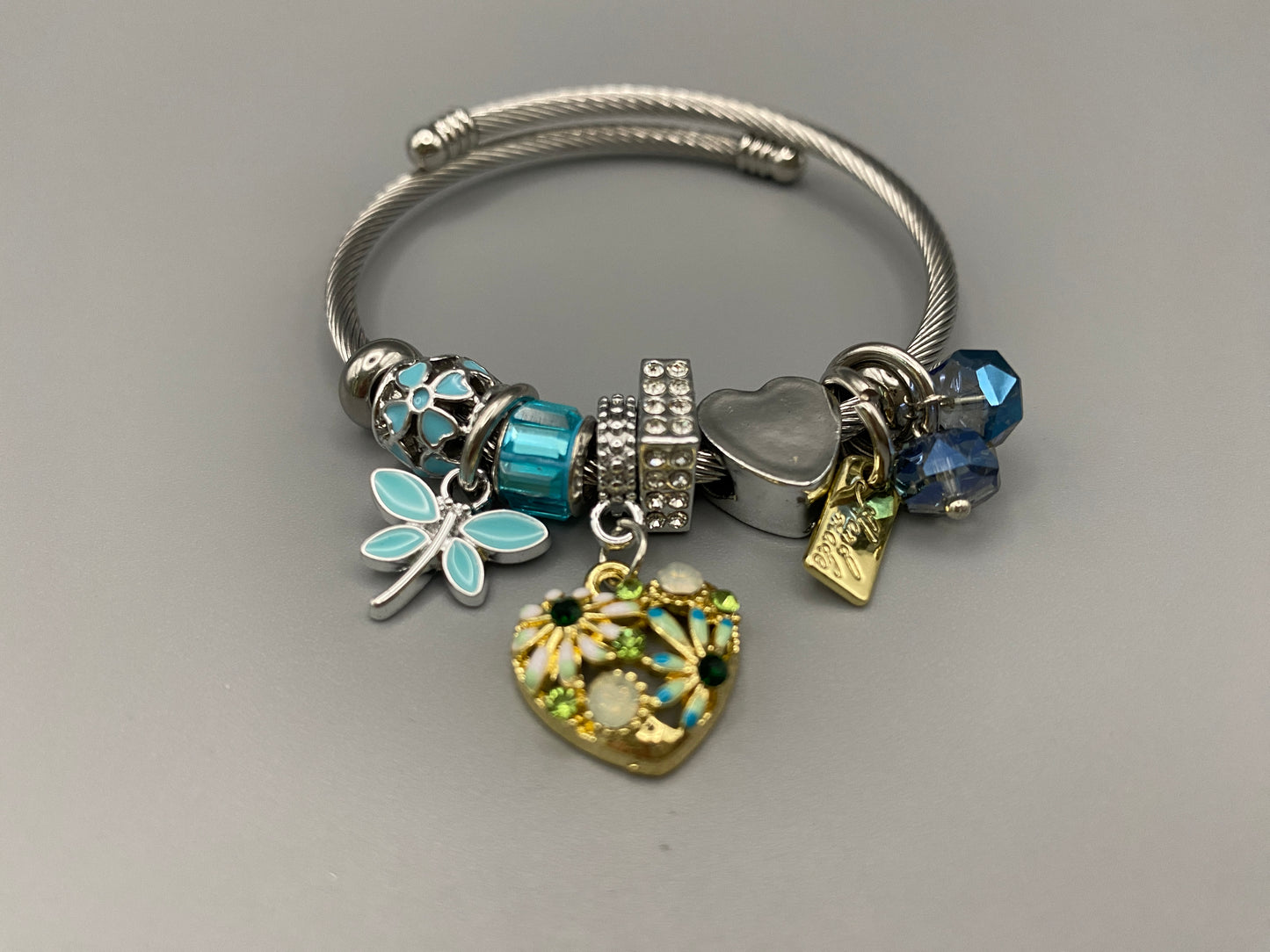 “Stellar Charm Bracelet in blue with playful charms including a heart, butterfly, and cube, crafted from high-quality stainless steel. Suitable for both women and kids, making it a perfect gift for any occasion.”