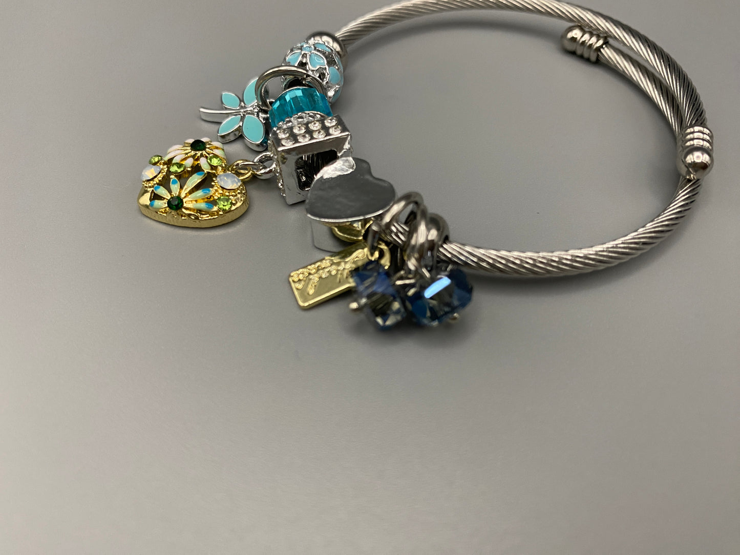 “Stellar Charm Bracelet in blue with playful charms including a heart, butterfly, and cube, crafted from high-quality stainless steel. Suitable for both women and kids, making it a perfect gift for any occasion.”