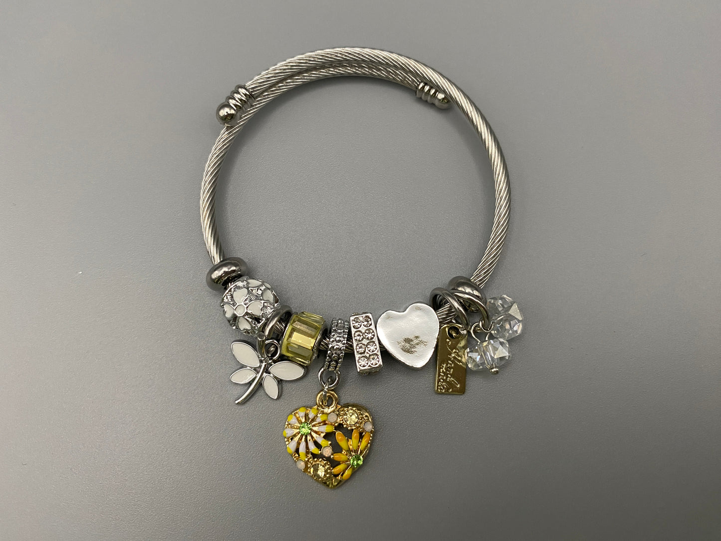 “Stellar Charm Bracelet in yellow with playful charms including a heart, butterfly, and cube, crafted from high-quality stainless steel. Suitable for both women and kids, making it a perfect gift for any occasion.”