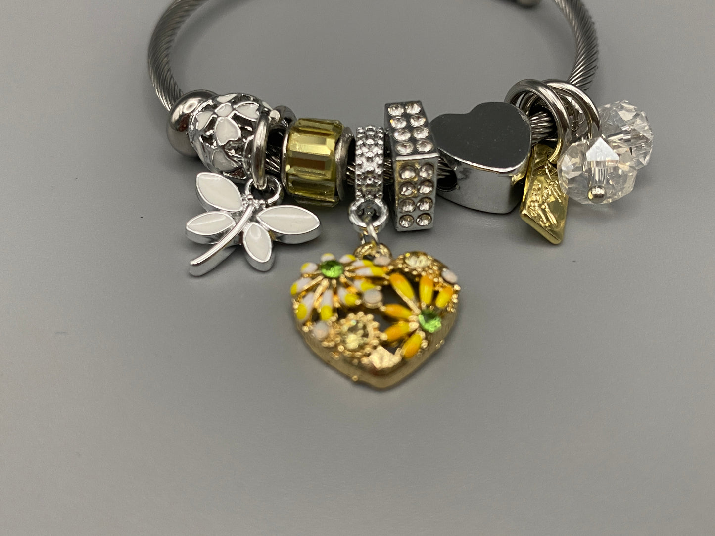 “Stellar Charm Bracelet in yellow with playful charms including a heart, butterfly, and cube, crafted from high-quality stainless steel. Suitable for both women and kids, making it a perfect gift for any occasion.”