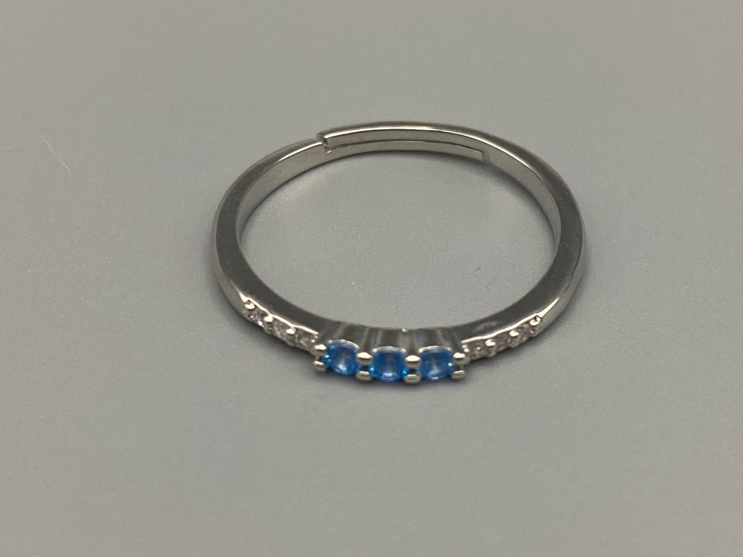 Tanvi Blue Ring: This stunning piece features alternating brilliant blue and clear cubic zirconia stones, set in a sleek silver-plated band. The adjustable fit ensures comfort for any finger size. The ring is non-tarnish and waterproof, maintaining its shine over time. Perfect for everyday wear, the Tanvi ring is your go-to accessory for timeless beauty.