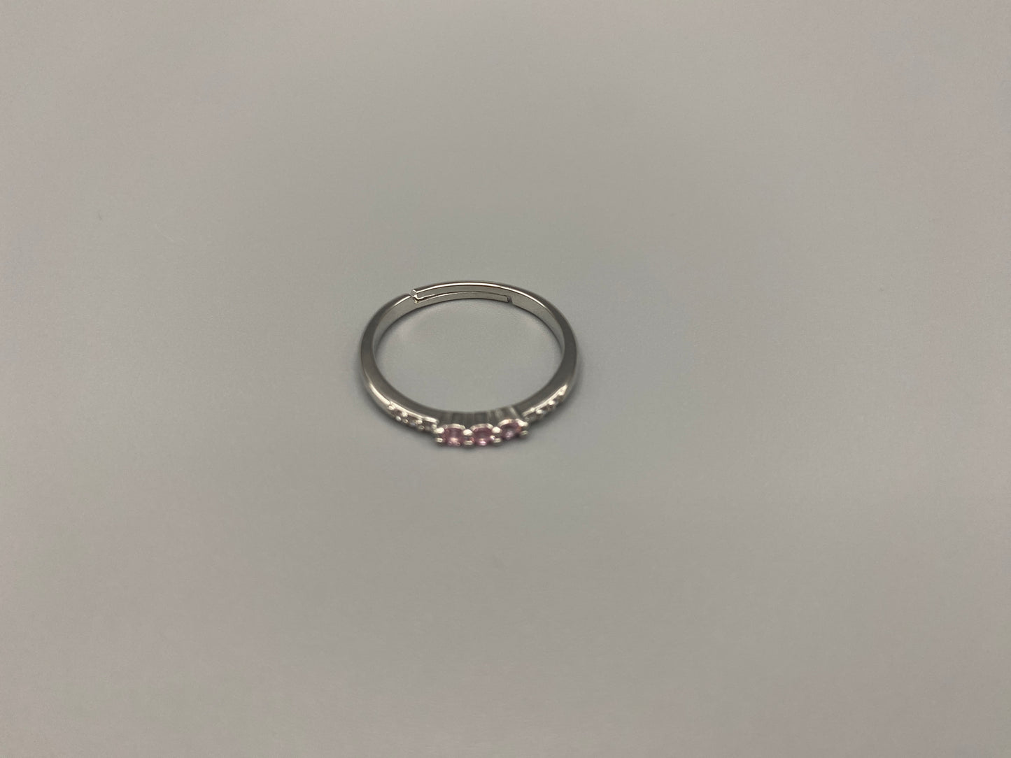 Tanvi Pink Ring: This stunning piece features alternating brilliant blue and clear cubic zirconia stones, set in a sleek silver-plated band. The adjustable fit ensures comfort for any finger size. The ring is non-tarnish and waterproof, maintaining its shine over time. Perfect for everyday wear, the Tanvi ring is your go-to accessory for timeless beauty.