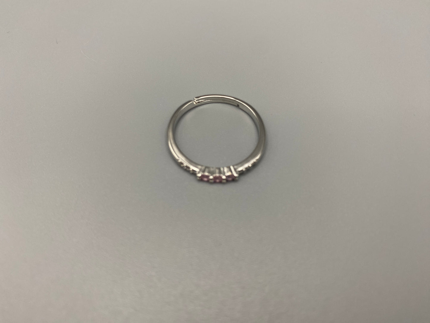 Tanvi Pink Ring: This stunning piece features alternating brilliant blue and clear cubic zirconia stones, set in a sleek silver-plated band. The adjustable fit ensures comfort for any finger size. The ring is non-tarnish and waterproof, maintaining its shine over time. Perfect for everyday wear, the Tanvi ring is your go-to accessory for timeless beauty.