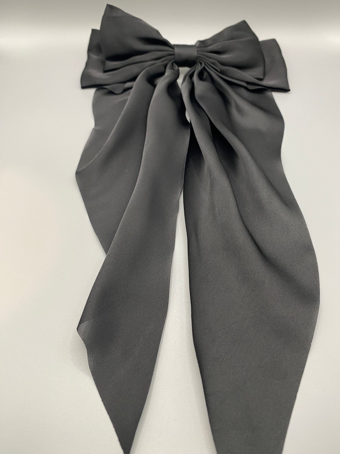 “The Amy Oversized Hair Bow in Black, crafted from high-quality satin with an oversized bowknot design. Features a minimalist spring clamp for a secure fit. Perfect for stylish updos, daily wear, and special occasions.”
