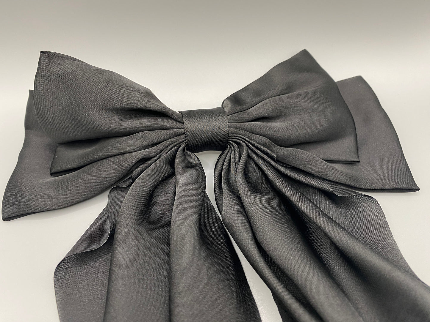 “The Amy Oversized Hair Bow in Black, crafted from high-quality satin with an oversized bowknot design. Features a minimalist spring clamp for a secure fit. Perfect for stylish updos, daily wear, and special occasions.”