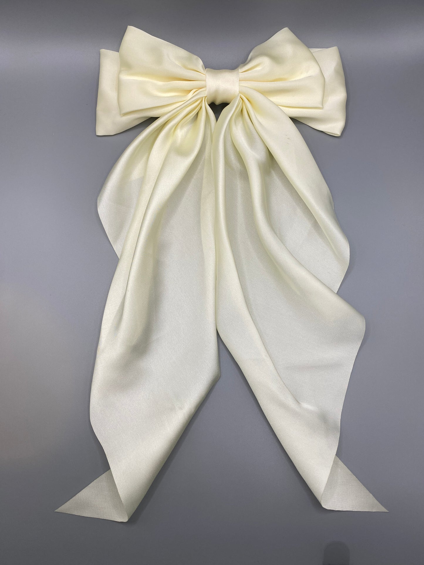 “The Amy Oversized Hair Bow in Cream, crafted from high-quality satin with an oversized bowknot design. Features a minimalist spring clamp for a secure fit. Perfect for stylish updos, daily wear, and special occasions.”