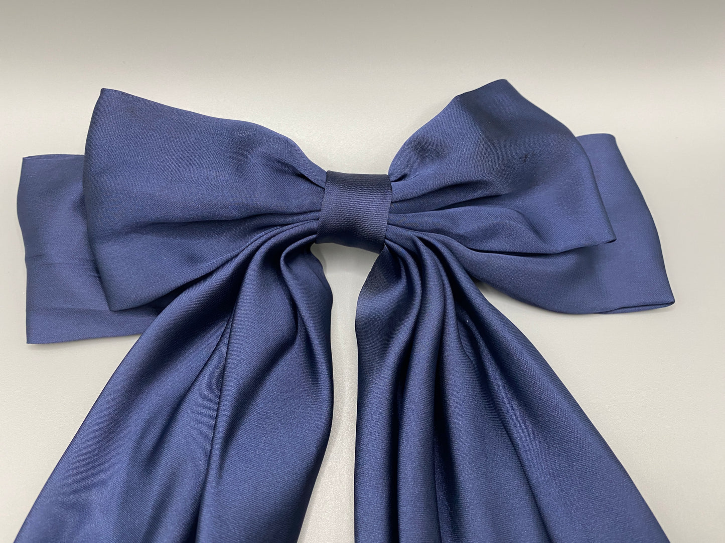 “The Amy Oversized Hair Bow in Navy Blue, crafted from high-quality satin with an oversized bowknot design. Features a minimalist spring clamp for a secure fit. Perfect for stylish updos, daily wear, and special occasions.”
