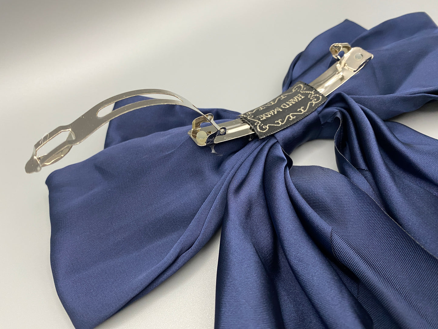 “The Amy Oversized Hair Bow in Navy Blue, crafted from high-quality satin with an oversized bowknot design. Features a minimalist spring clamp for a secure fit. Perfect for stylish updos, daily wear, and special occasions.”