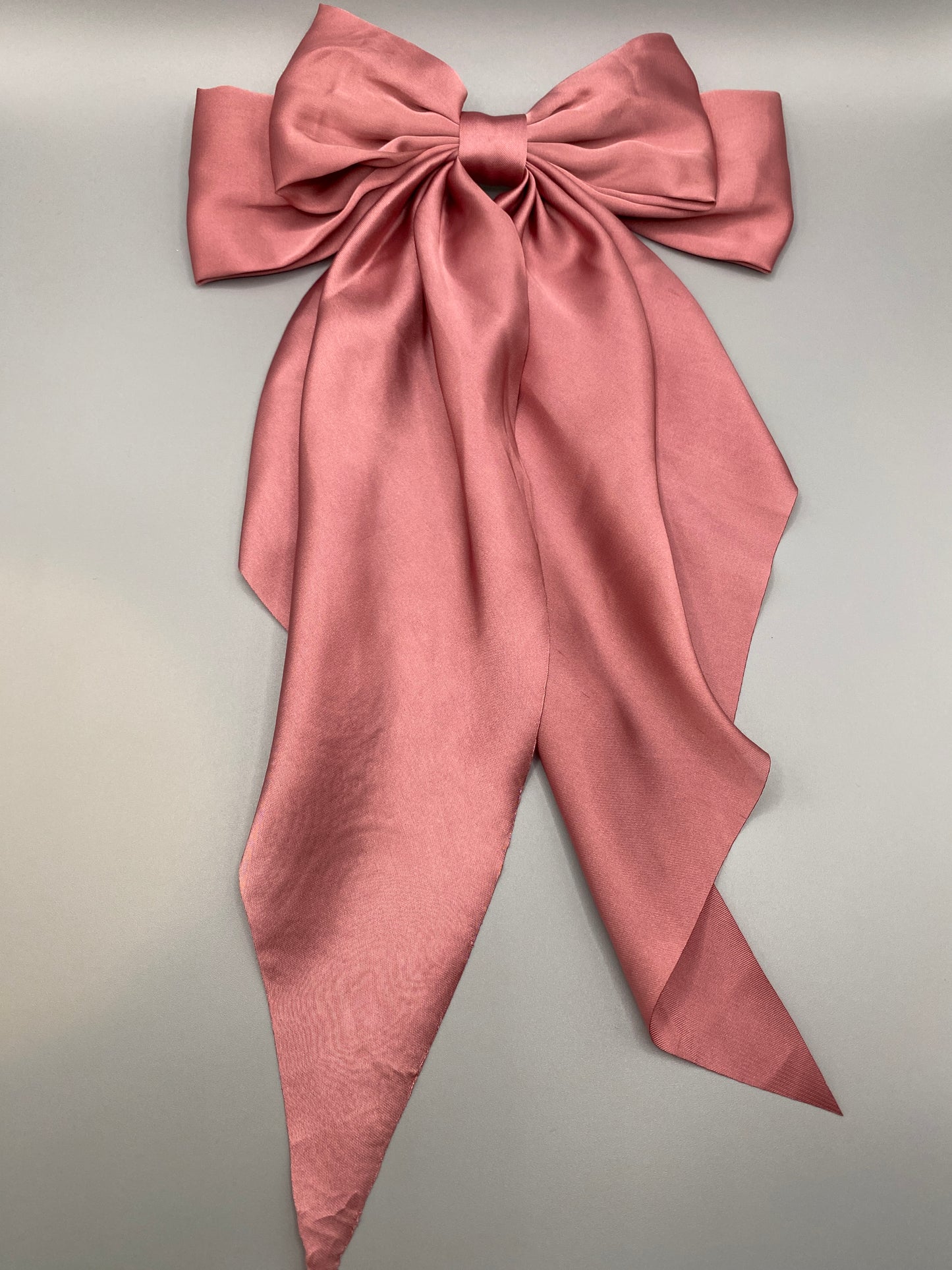 “The Amy Oversized Hair Bow in Pink, crafted from high-quality satin with an oversized bowknot design. Features a minimalist spring clamp for a secure fit. Perfect for stylish updos, daily wear, and special occasions.”