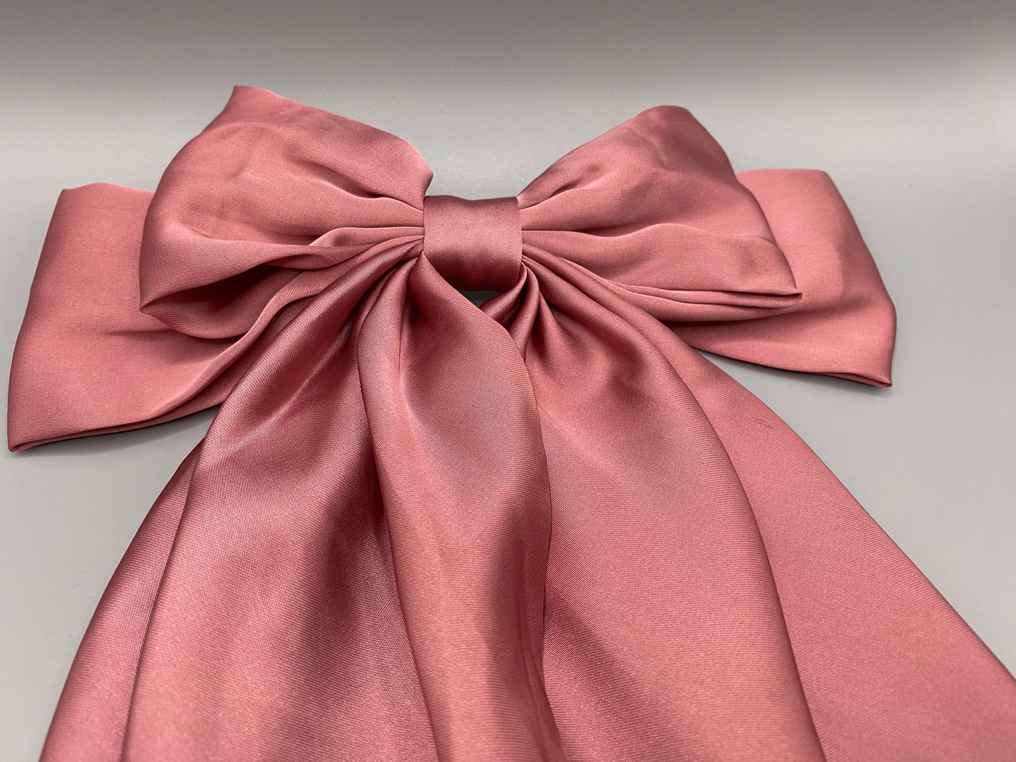 “The Amy Oversized Hair Bow in Pink, crafted from high-quality satin with an oversized bowknot design. Features a minimalist spring clamp for a secure fit. Perfect for stylish updos, daily wear, and special occasions.”