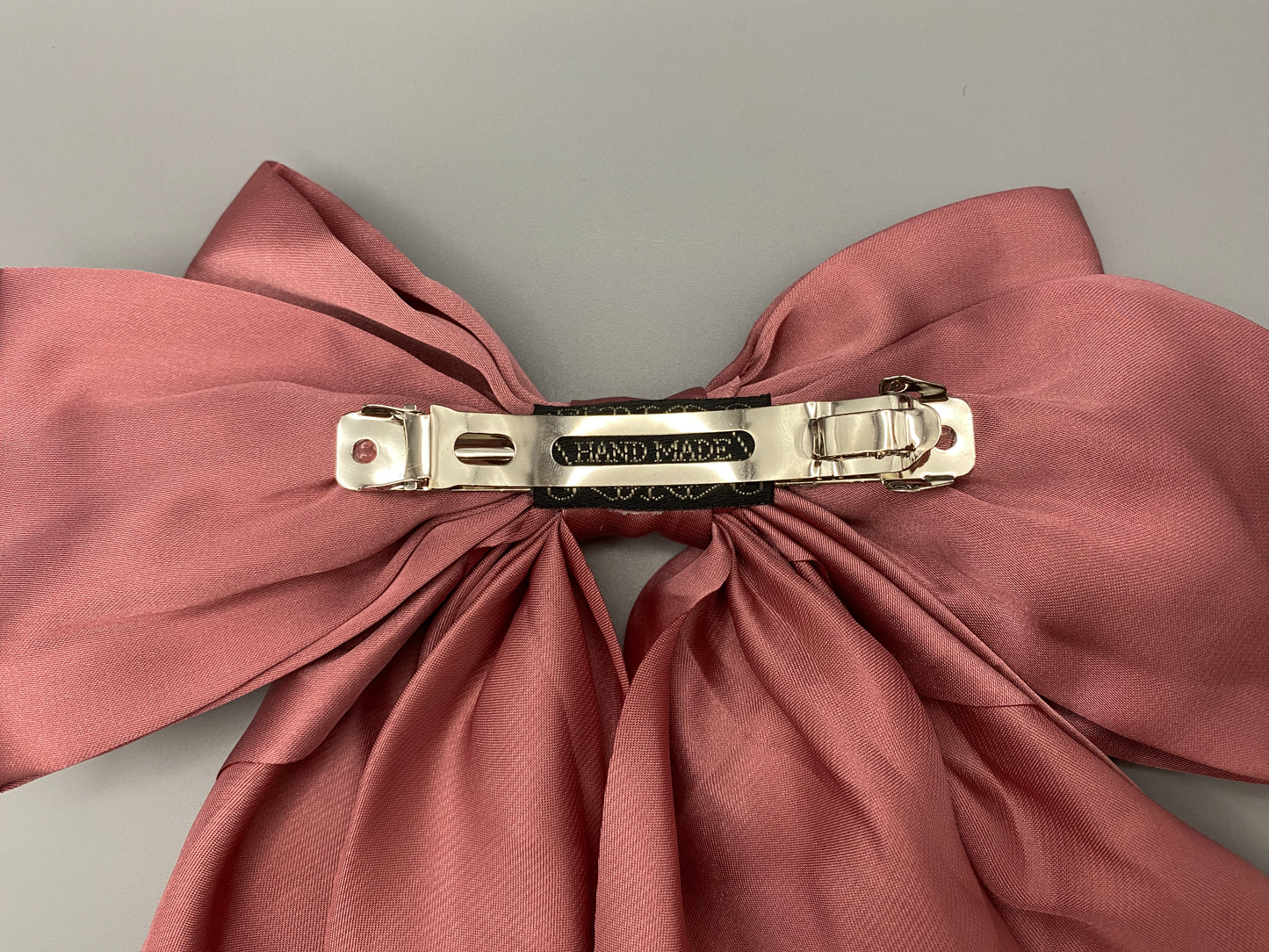 “The Amy Oversized Hair Bow in Pink, crafted from high-quality satin with an oversized bowknot design. Features a minimalist spring clamp for a secure fit. Perfect for stylish updos, daily wear, and special occasions.”